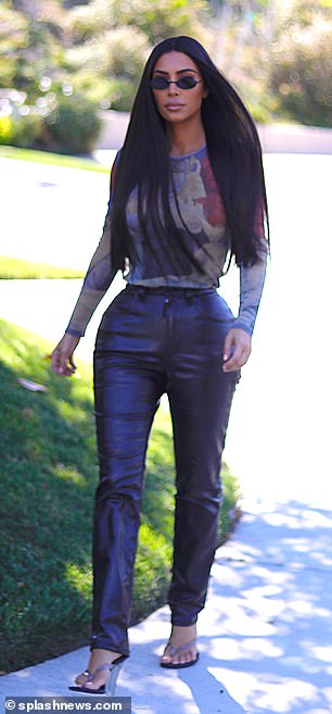 Unique style: Kim opted for a long sleeved sheer top with various designs throughout