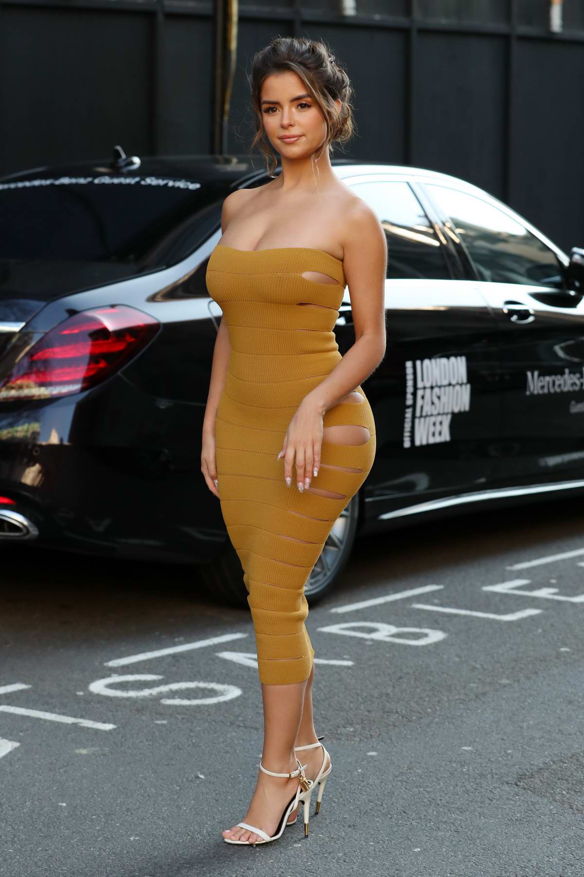 Demi Rose stuns in a mustard yellow strapless dress while out during London  Fashion Week in